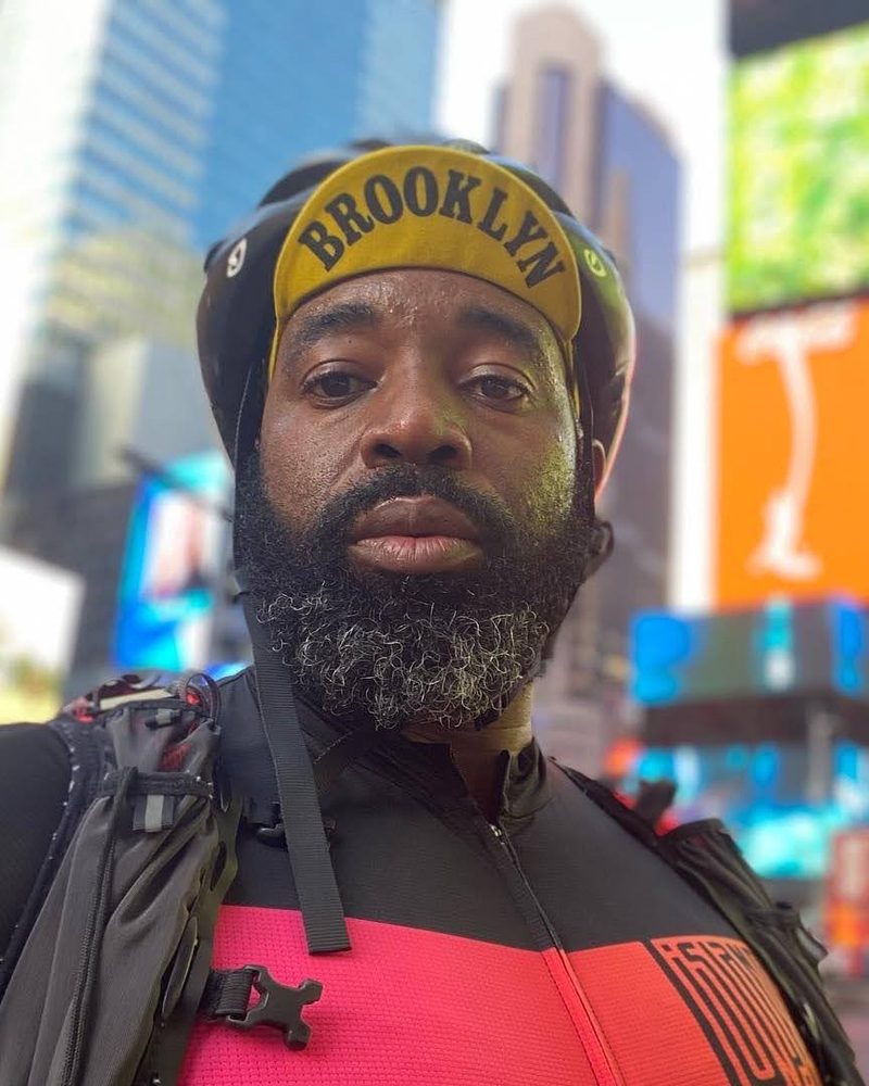 Kenny Akpan in cycling kit and a Brooklyn cap in Times Square, New York